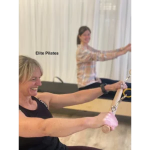 a pilates tower class in progress two female clients performing tower exercise