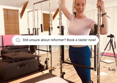 Pilates studio owner standing with the pilates Tower bed before a class in Newton Abbot